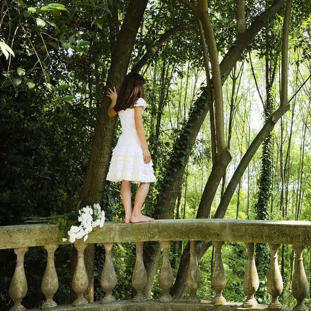 girl walking on bridge over pond